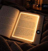 Kyrena Leselicht in Weiß auf aufgeschlagenem Buch im Bett, Licht nur auf der Seite
